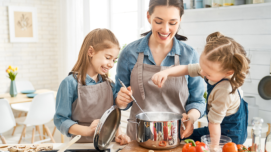 Mother cooking with daughters